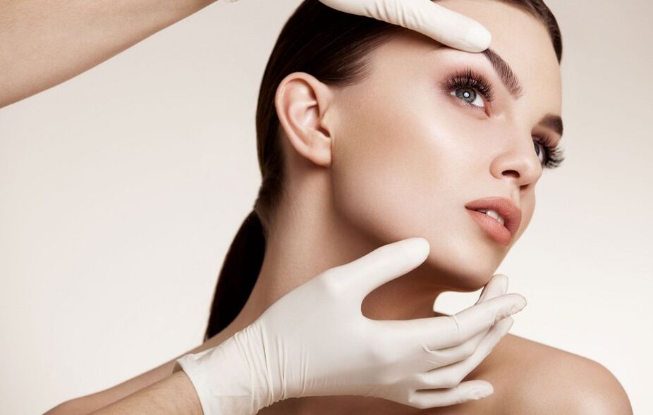 a cosmetologist examines the facial skin before rejuvenation